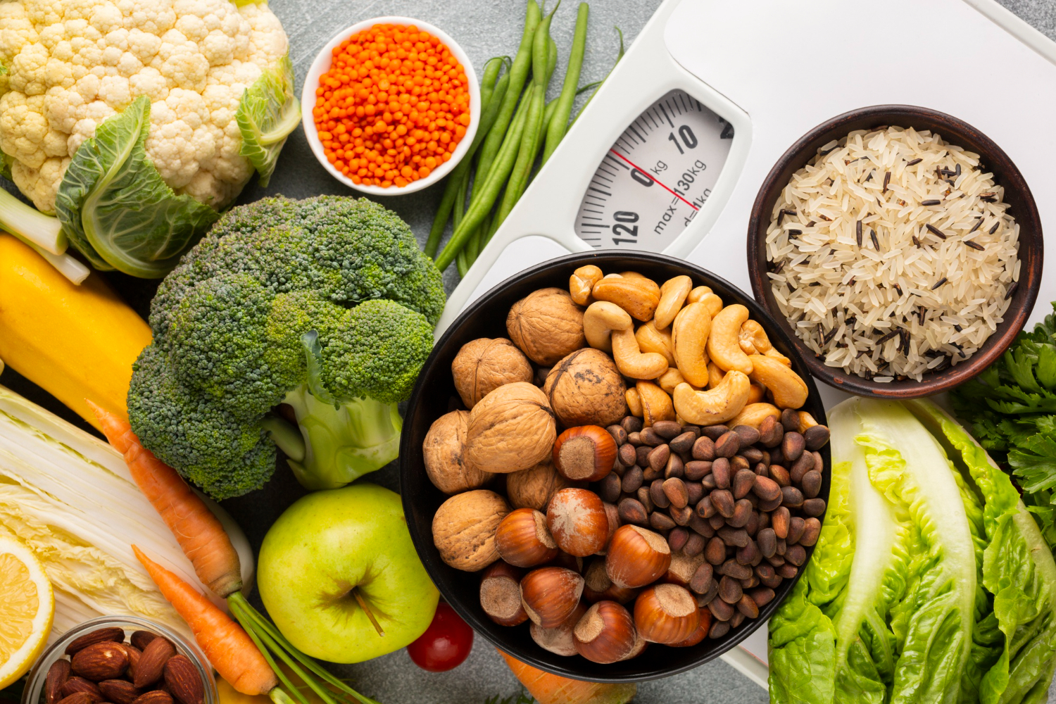 Mesa com alimentos saudáveis, incluindo vegetais, frutas, castanhas, arroz e leguminosas, simbolizando uma alimentação equilibrada e nutritiva.