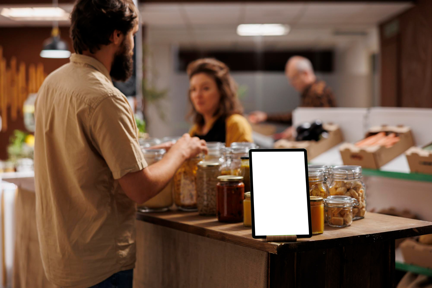 Homem escolhendo cereais e produtos naturais em loja sustentável, com potes de vidro e tablet em destaque no balcão, representando o conceito de redescobrir a saúde com nutrição inteligente e criatividade.